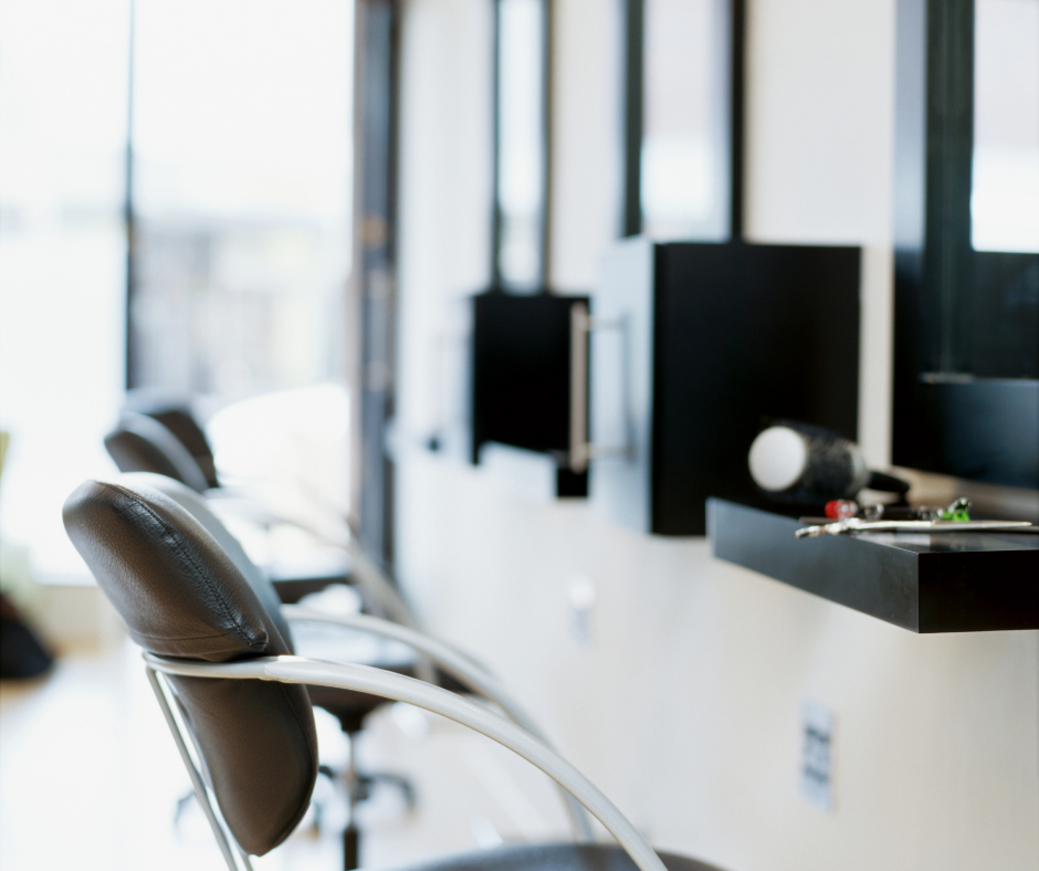 Elegant salon interior with a "For Sale" sign, showcasing the partnership with Meritus Group Business Brokerage.